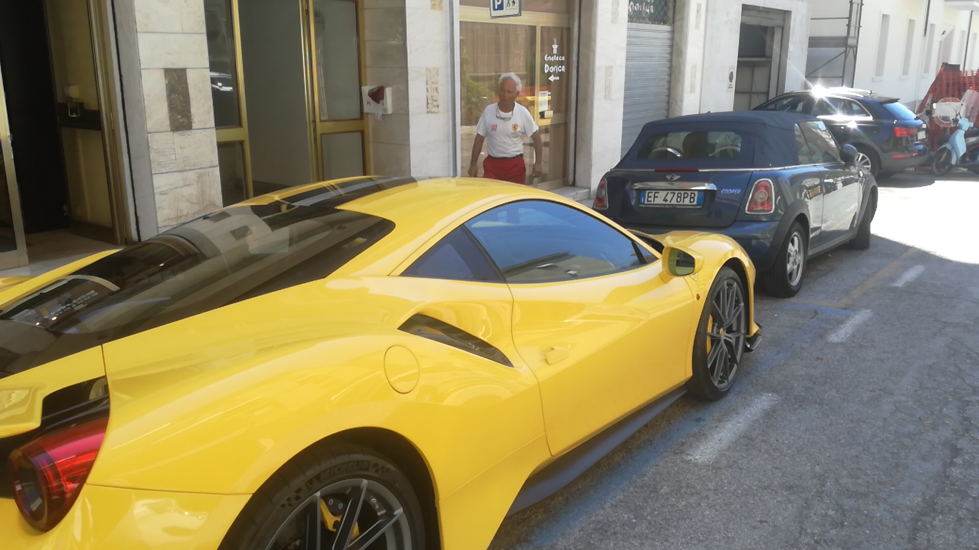 Seconda vista dell'auto gialla davanti all'ingresso dell'autofficina